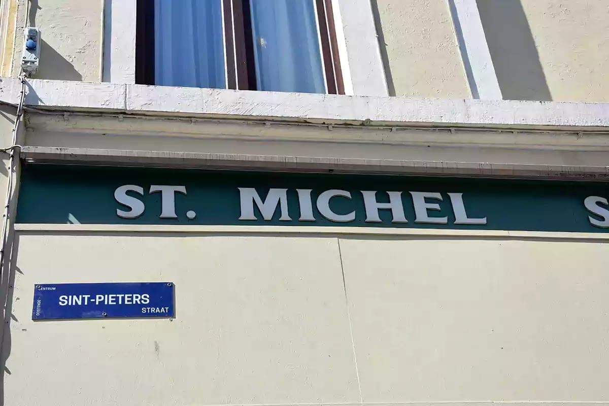 Plastický nápis ST. MICHEL na fasádě nad cedulí Sint-Pietersstraat