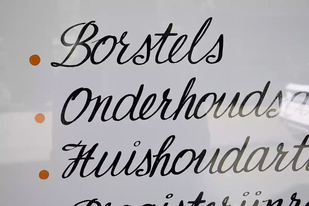 Psací písmo Borstels a Onderhoudsartikelen namalované na výloze