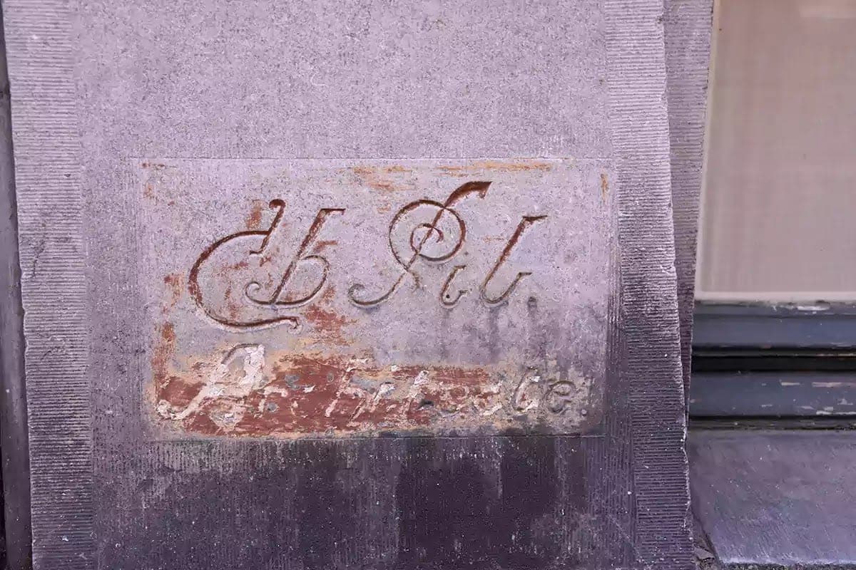 Tesaný podpis architekta Ch. Pil se zbytky červené barvy