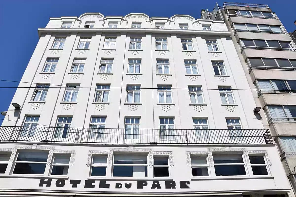 Bílá fasáda s art deco nápisem Hotel du Parc