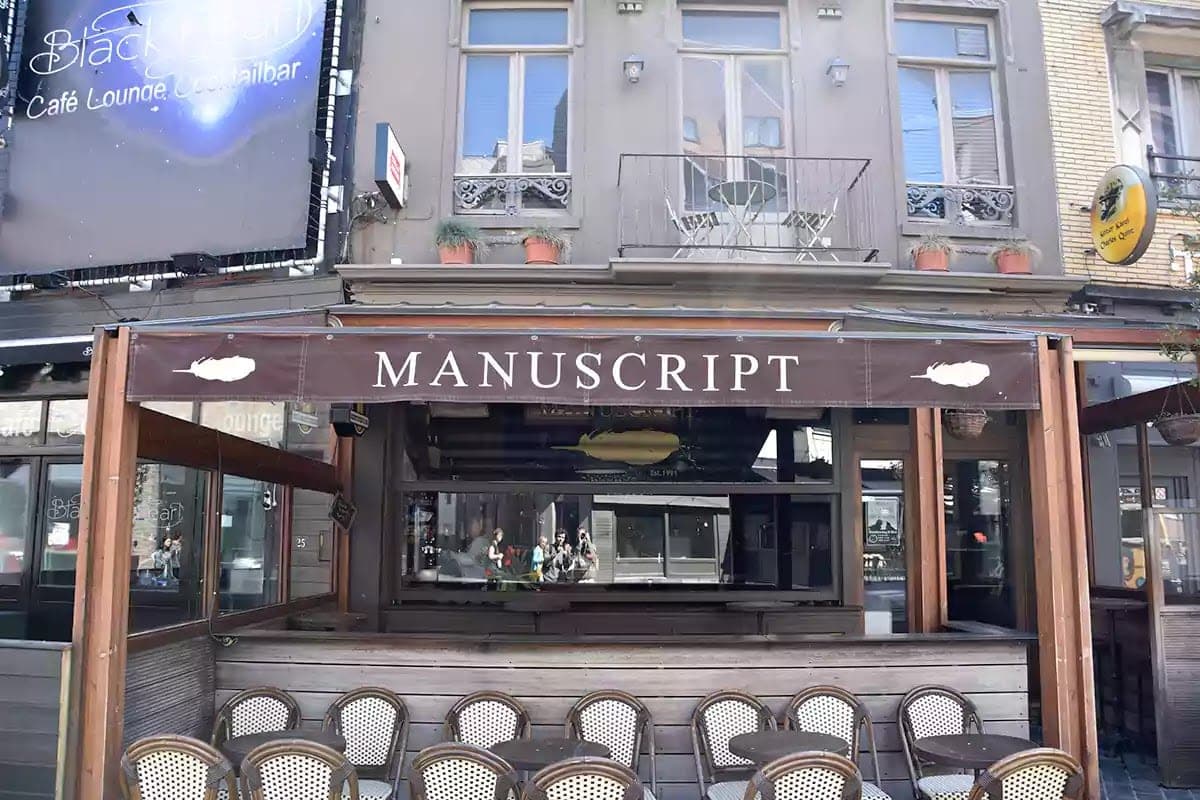 Markýza kavárny Manuscript s nápisem a kresbou brků