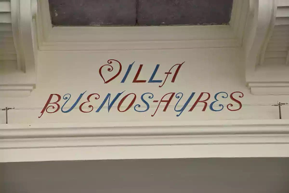 Červenomodrý malovaný nápis Villa Buenos-Ayres na fasádě