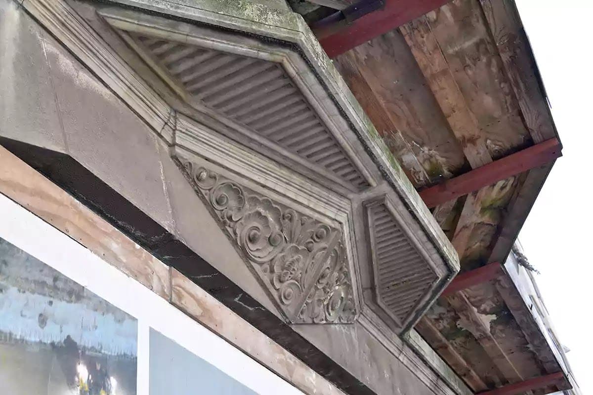 Kamenný ornamentální reliéf pod balkonem domu