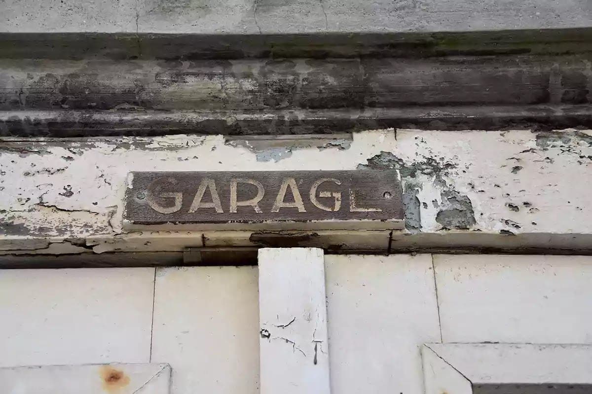 Oprýskaný nápis Garage na desce nad vraty