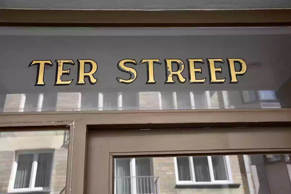 Zlacený nápis Ter Streep na skle nad dveřmi