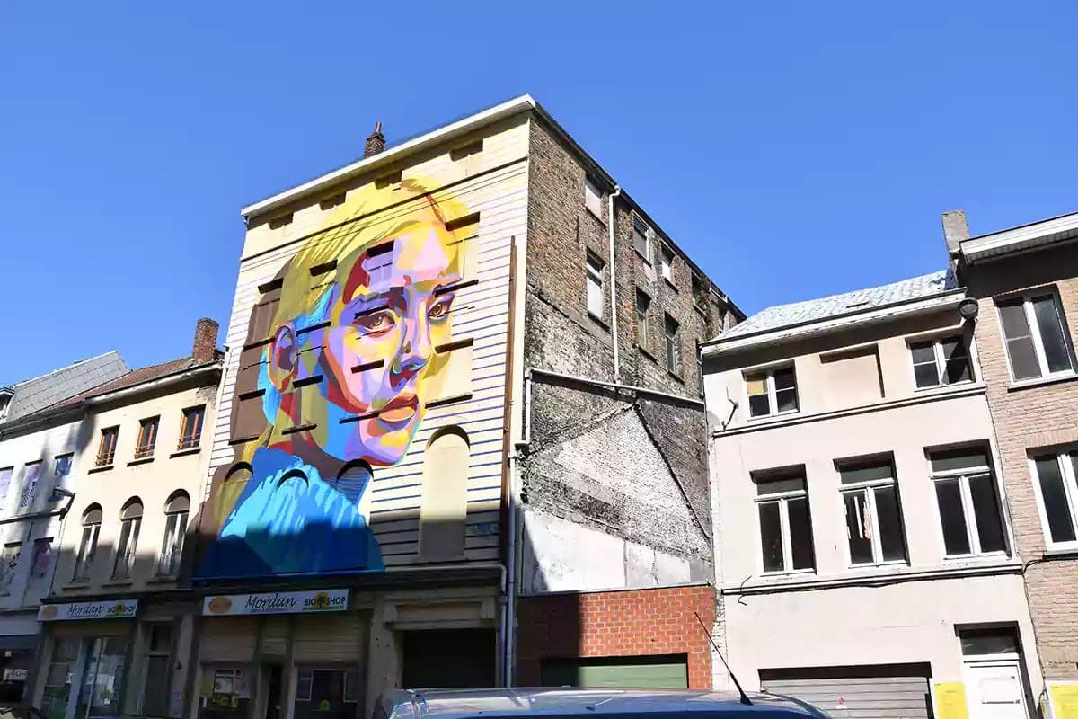 Barevný nástěnný portrét ženy na štítu domu