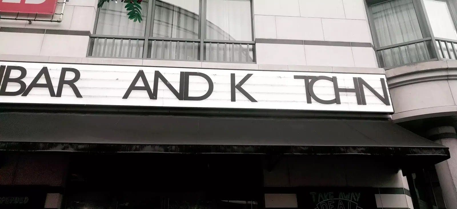Nápis BAR AND KITCHEN, ze kterého vypadla písmena