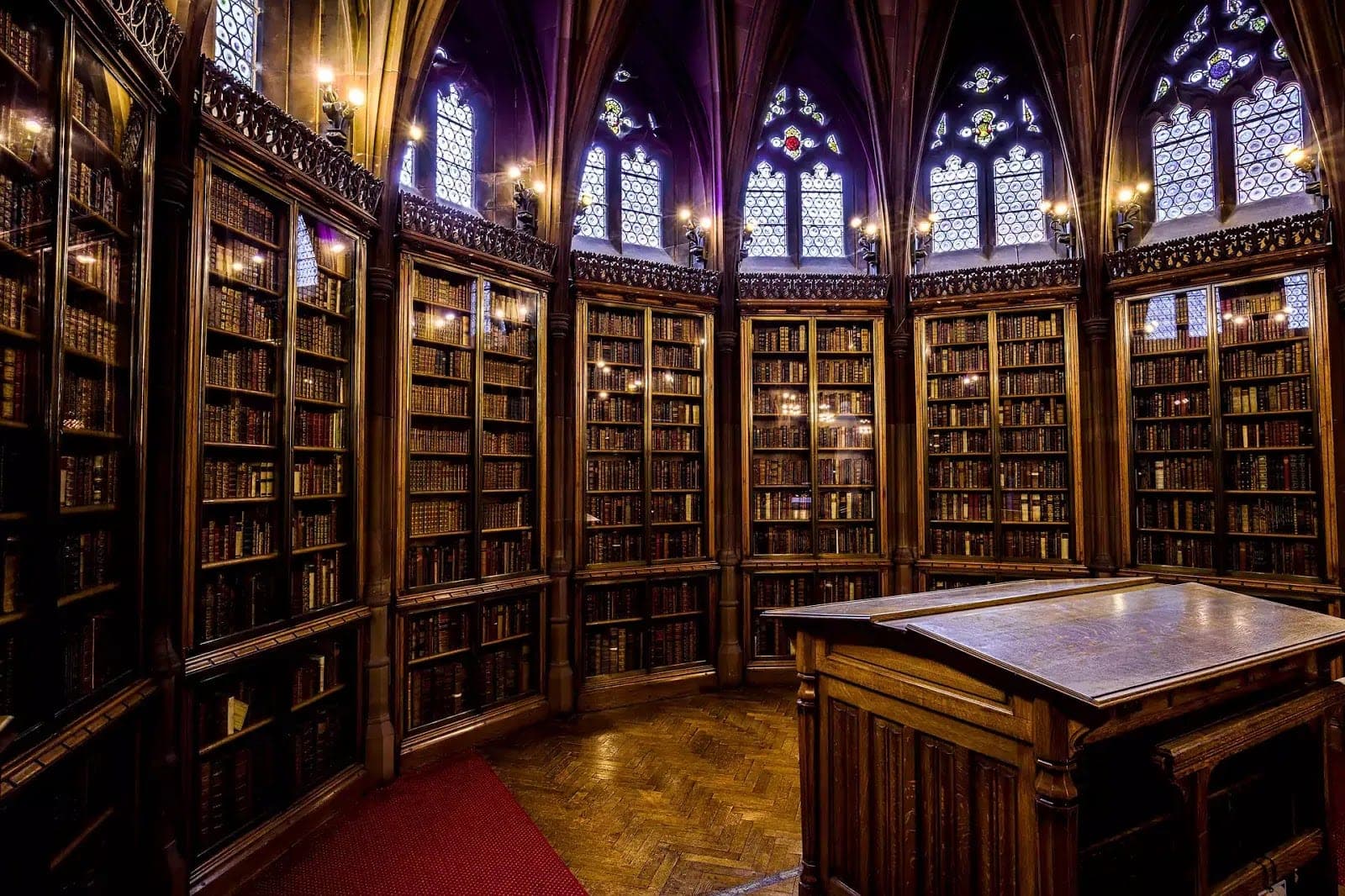 Gotický sál knihovny John Rylands s dřevěnými regály starých knih